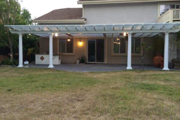 Outdoor dining area under a combination patio roof with adjustable shade panels installed in Clarksburg, CA