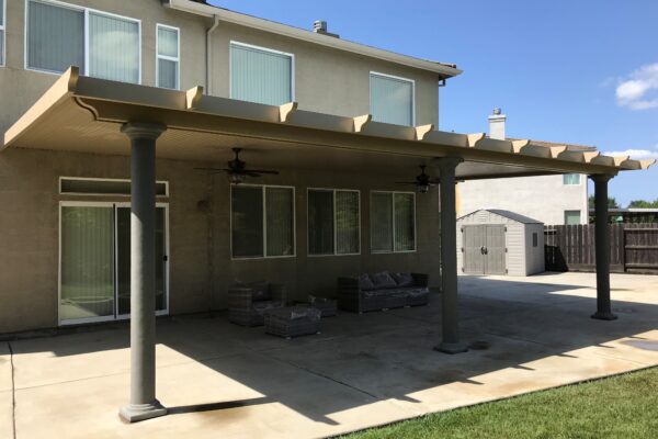 Solid patio cover with round stucco beams in Sacramento, CA
